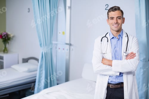 Preview: Male physician standing by hospital ward bed monitoring panel with stethoscope, copy space