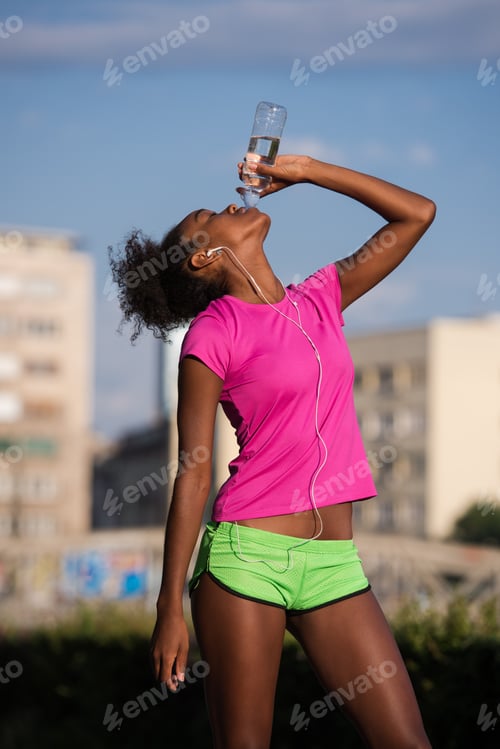 Preview: african american woman drinking water after jogging