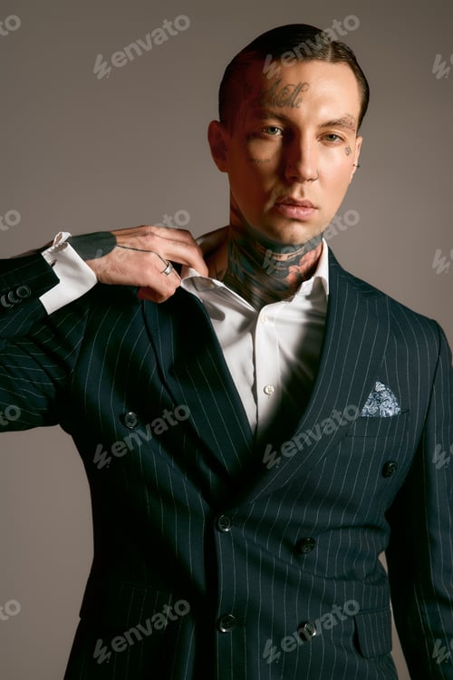 Preview: Stylish young man showcasing modern fashion with striking tattoos in an elegant setting