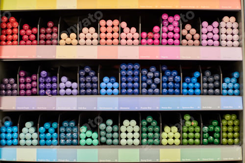 Preview: Colored pens, pencils, markers on shelf in stationery shop