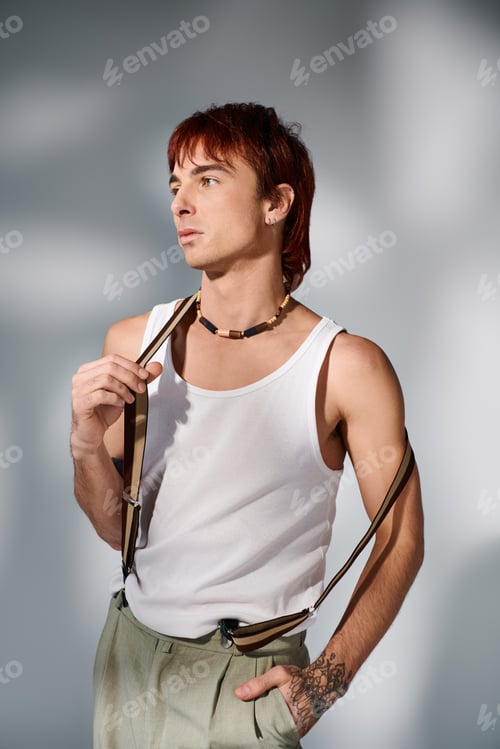 Preview: Fashionably unconventional: man in white tank top holding suspender