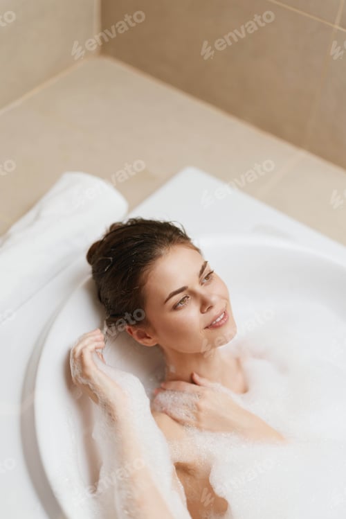 Preview: Relaxed young woman enjoying a bubble bath, surrounded by foam and soft lighting. Self-care and