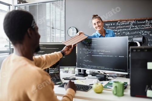Preview: Woman giving tablet pc to her colleague