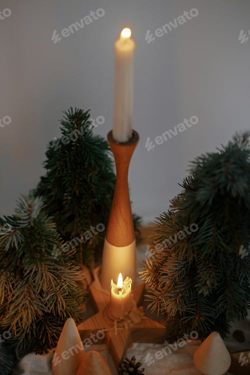 Preview: Stylish christmas candles and decorations on wooden table in evening scandinavian festive room