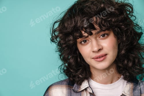 Preview: Pretty happy woman with curly brunette hair standing