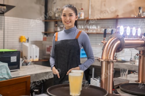 Preview: Portrait of Asian bartender girl hand at beer tap pouring , waitress or staff serve and craft