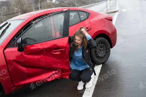 Preview: Woman sits near a broken car after an accident. call for help. car insurance