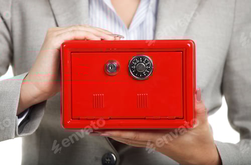 Preview: Businesswoman holding red safe in her hands