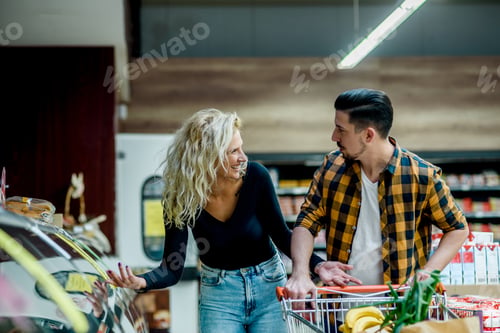 Preview: Couple in a supermarket with shopping cart while grocery shopping