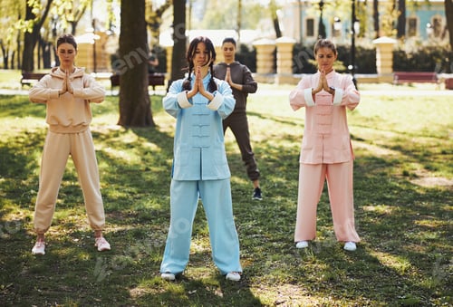 Preview: Trainer and students of qigong holding hand in praying gesture