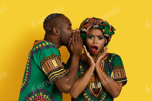 Preview: Black man sharing secrets with girlfriend, african couple on yellow