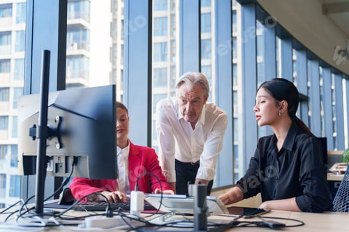 Preview: Diverse business team collaborating on a project in a modern office with city views