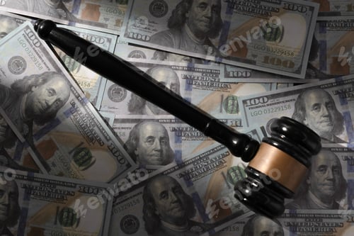 Preview: Black gavel on a pile of one hundred US dollar bills.