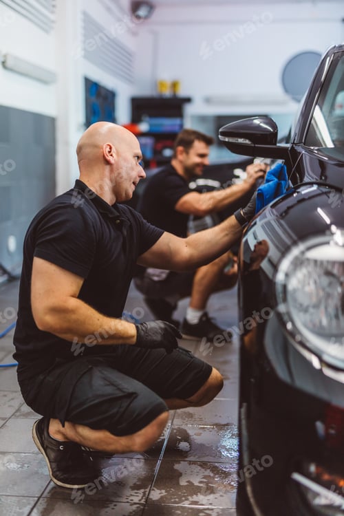 Preview: Service man washing car before detailing in workshop.