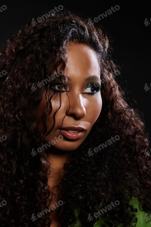 Preview: Captivating portrait of a beautiful woman with luscious curls on a dark backdrop