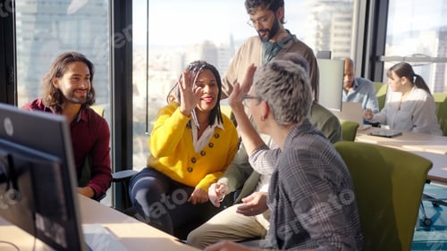 Preview: Diverse team high five in modern office