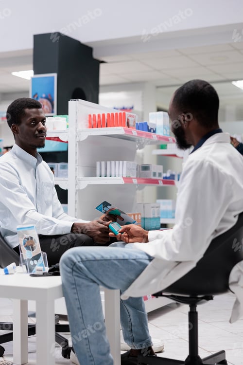 Preview: African american pharmacist measuring patient blood sugar with glucometer