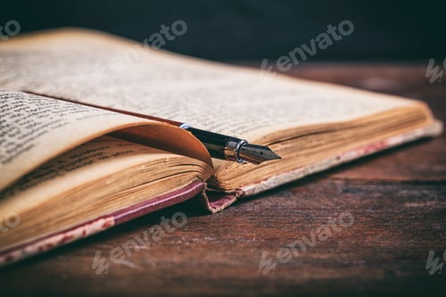 Preview: Vintage book and ink pen on a wooden desk