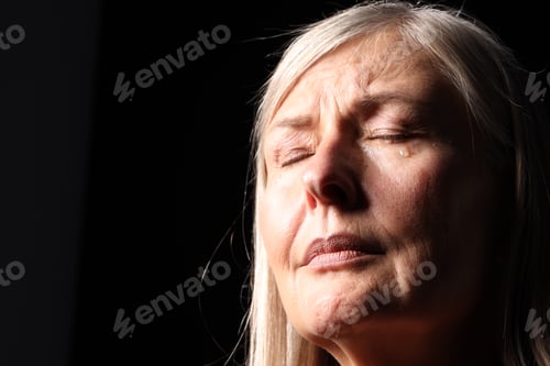 Preview: Senior woman crying on black background, closeup. Space for text