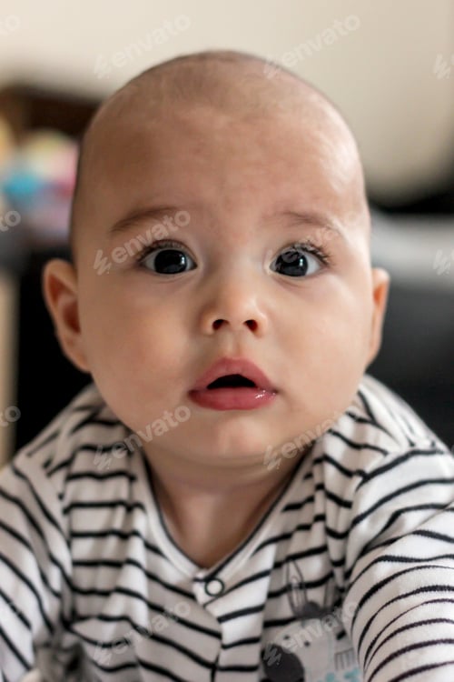 Preview: Cute little baby starts to crawl. Bald infant on the floor