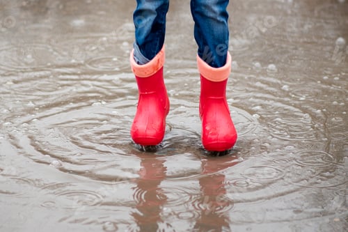 Preview: A cute little girl red boots jump in puddles and has a fun. Happy childhood. Early spring. Emotions.