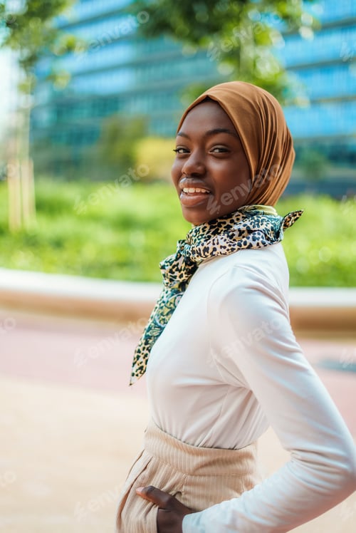 Preview: Black woman in hijab and scarf standing on street