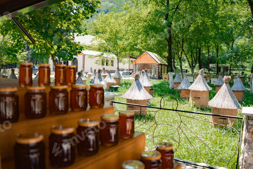 Preview: stack of jars with honey by apiary