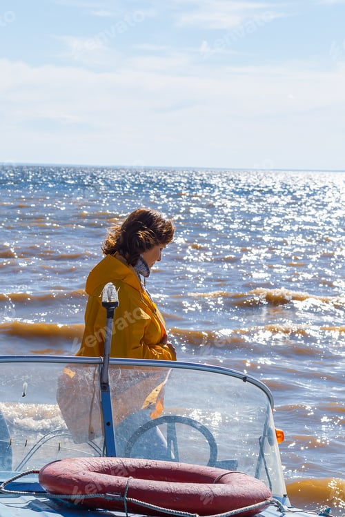 Preview: Woman resting on a boat on a sunny autumn day in the sea, river, lake