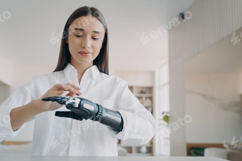 Preview: Happy handicapped girl is setting the prosthesis functions at home. Modern orthopedic technology.