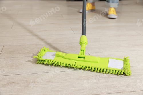 Preview: Woman cleaning floor with mop at home, closeup