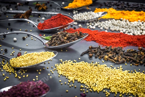 Preview: Collection of spices are spread out on a table. The spices include cumin, paprika, and turmeric