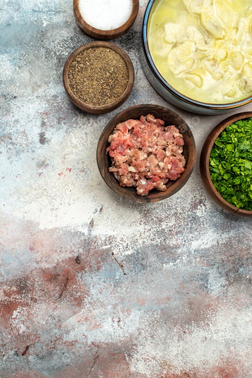 Preview: top view dushbara bowls with different spices greens meat on nude background copy space
