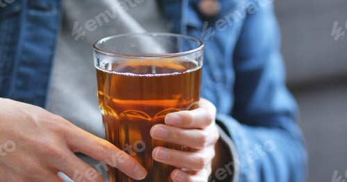 Preview: Woman holding glass of tea