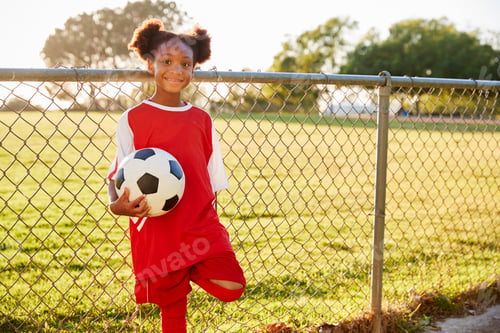 Preview: Pre teen black girl holding a soccer ball looking to camera