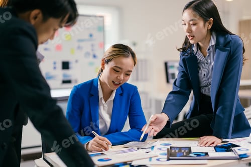 Preview: Team of asian businesspeople are discussing a project, analyzing statistics on charts and graphs, wo