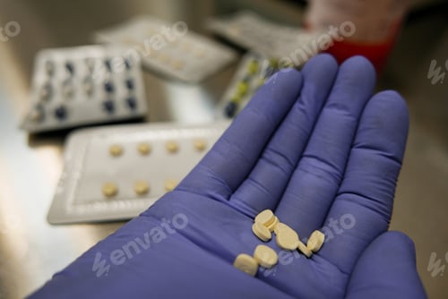 Preview: Close-up, personal perspective of hand in glove holding pills.