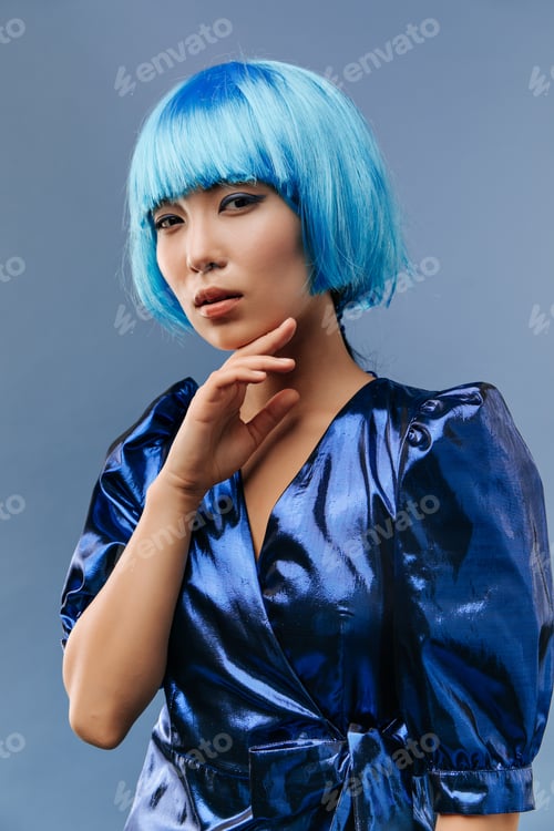 Preview: Stylish cool asian girl with short unusual hairstyle and modern makeup in bright trendy dress looki