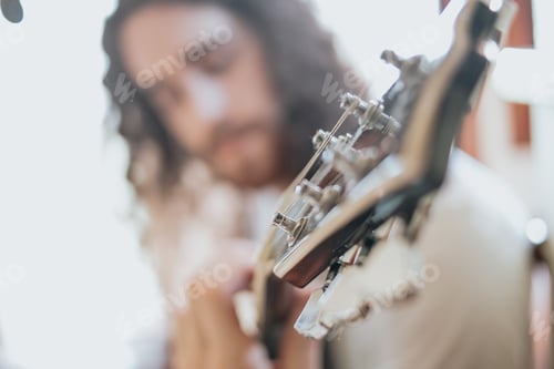 Preview: Attractive man with long hair playing acoustic guitar outdoors, hippie, relax, park lifestyle, hobby