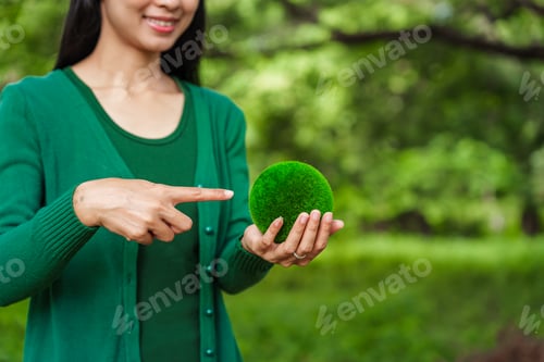 Preview: Forest conservationist holds small globe in hands,symbolizing global responsibility for protecting