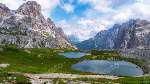 Preview: Tre Cime di Lavaredo peaks or Drei Zinnen with small water pond reflections in the Dolomites Italy