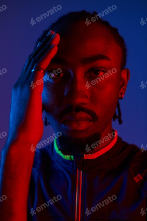 Preview: Stylish young man expresses confidence in neon-lit studio setting