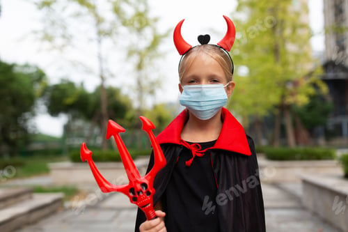 Preview: Portrait of cute Little Girl in costume of evil in park. Happy Halloween during coronavirus covid-19