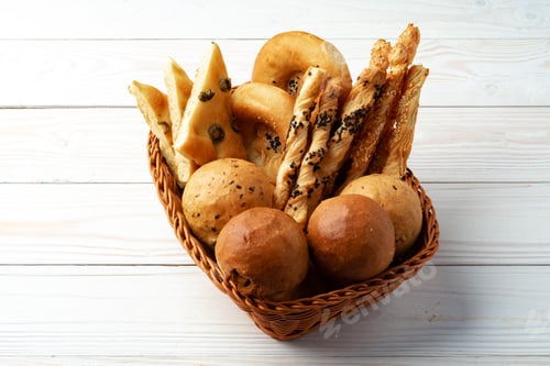 Preview: Bakery products in straw bread basket on wooden table