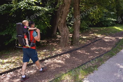 Preview: Young man and his baby girl in a backpack carrier on a hike