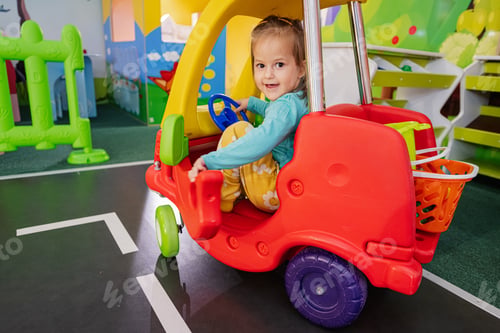 Preview: Kids playing at indoor play center playground , girl in toy car.