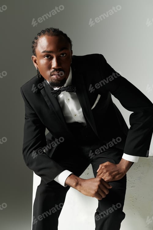 Preview: Young African American man in a stylish suit posing confidently against a grey background