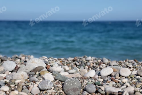 Preview: Bank of pebbles with the sea and beach in the background
