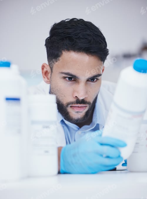 Preview: Laboratory, man or scientist reading container at pharmaceutical laboratory checking stock or info