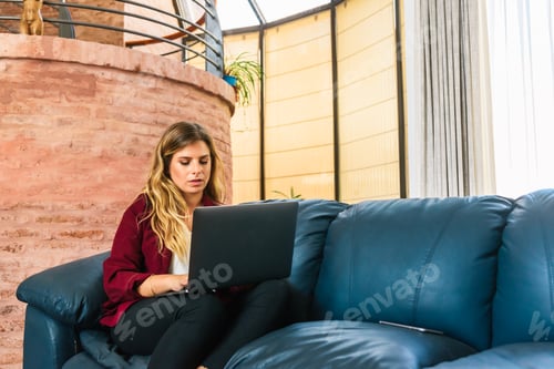 Preview: Business woman using laptop in her apartment.