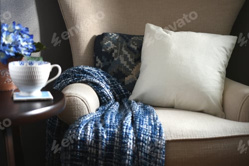 Preview: Plain canvas throw pillow suitable for mock up mockup on a chair with blue throw blanket